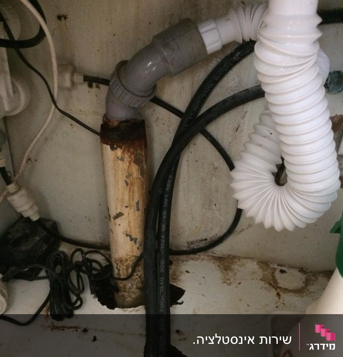 צינורות פלסטיק מתחת לכיור עם חלודה